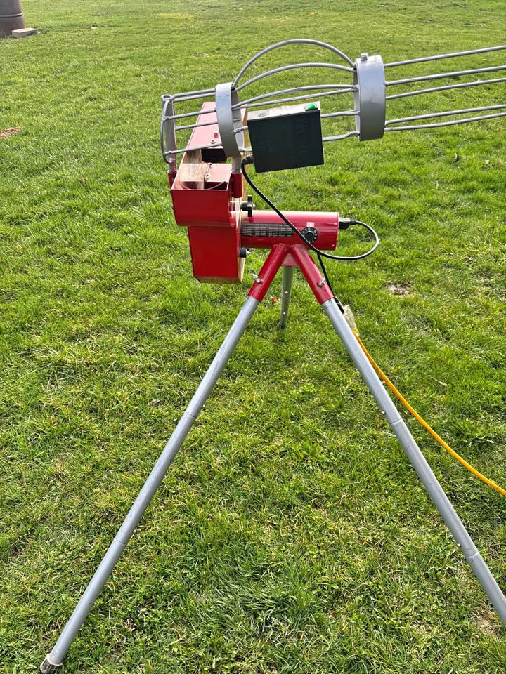 Heater softball pitching machine